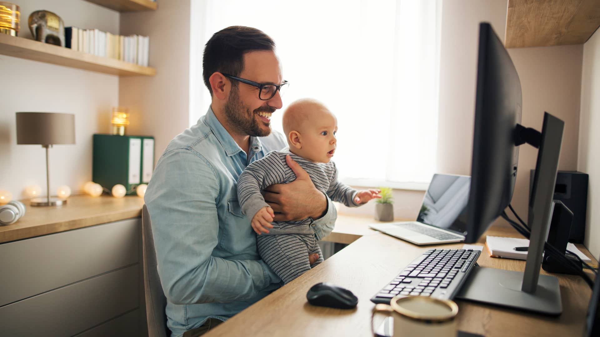 Padre con su bebé en plena consulta online gracias a su seguro Adeslas