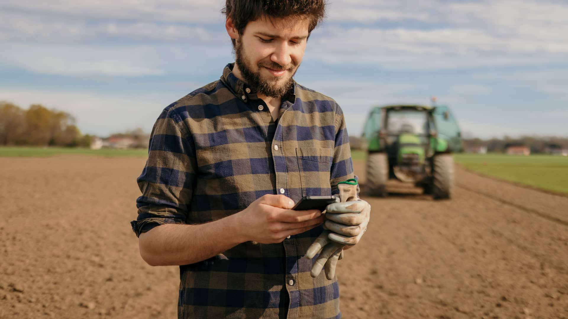 Joven agricultor descargando app de agroseguro en su smartphone