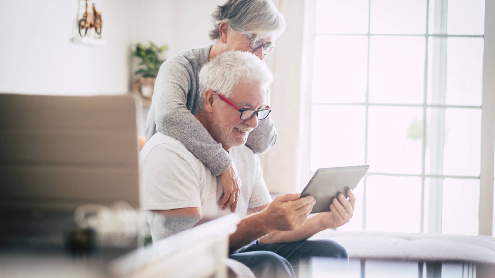 Pareja adulta de jubilados viendo en su tablet el seguro de decesos de allianz