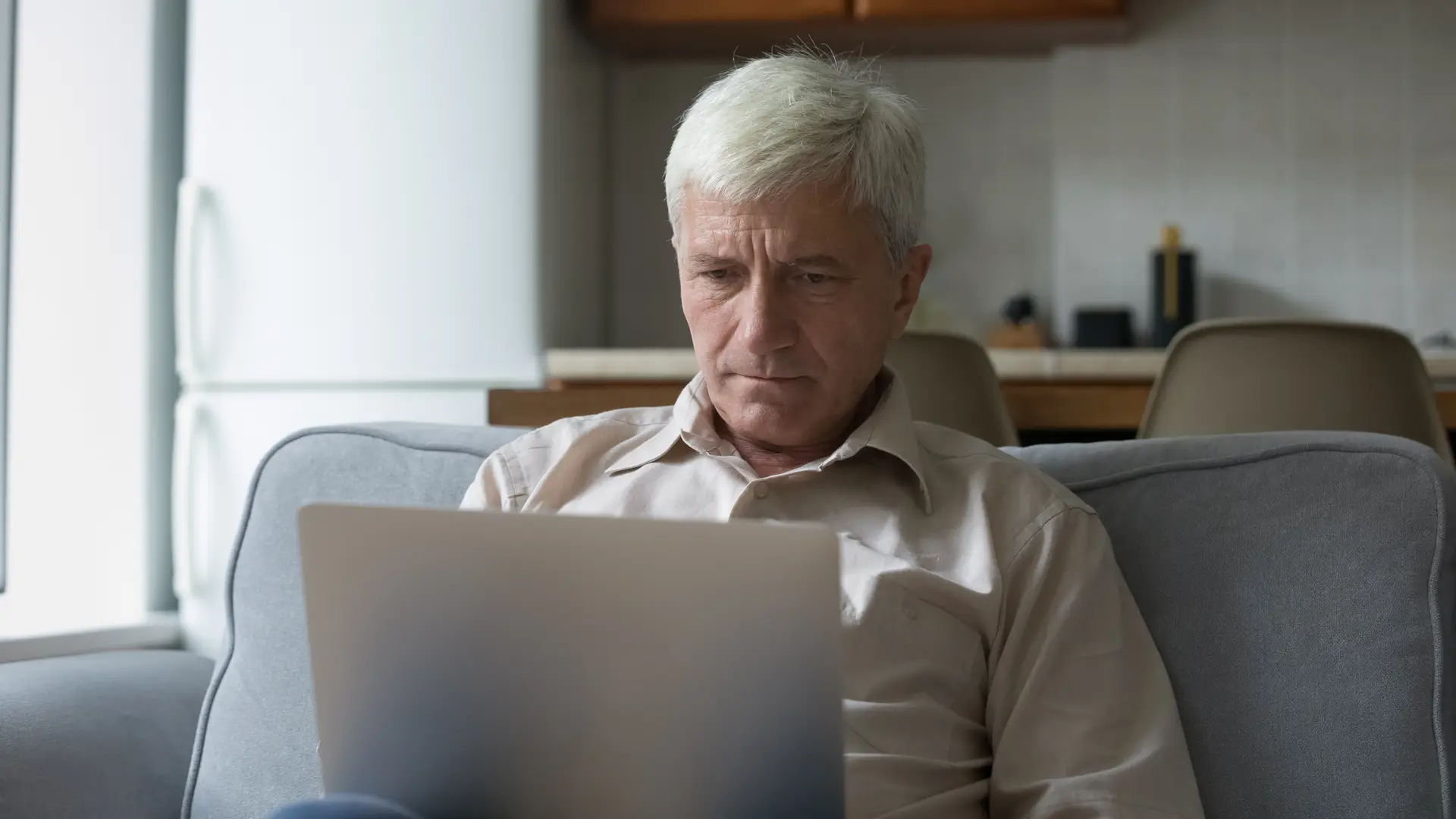 Un señor serio mirando en el ordenador que no puede contratar un seguro de dependencia con los seguros de vida de Allianz