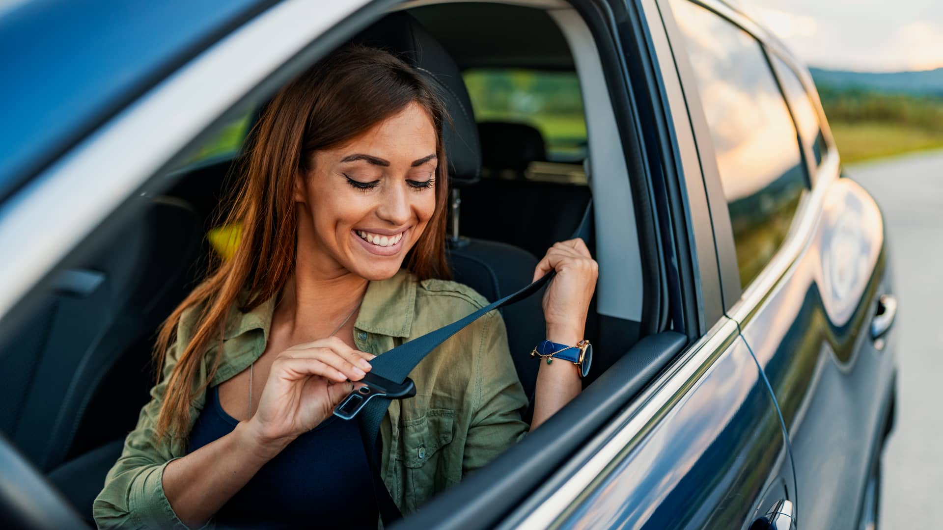 Mujer sonriente con su coche asegurado con atlantis