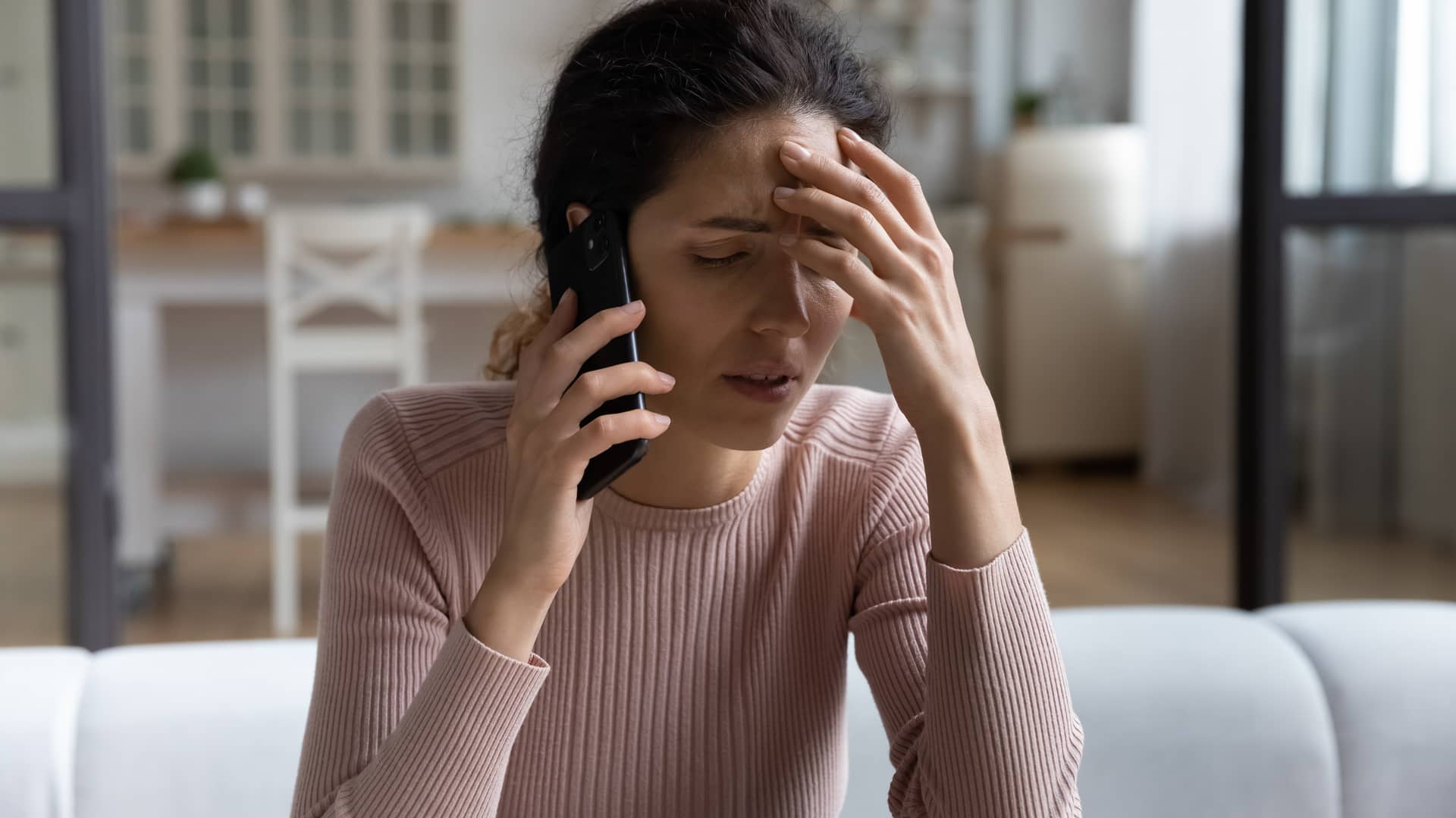 una mujer disgustada poniendo por telefono una reclamacion a la aseguradora axa