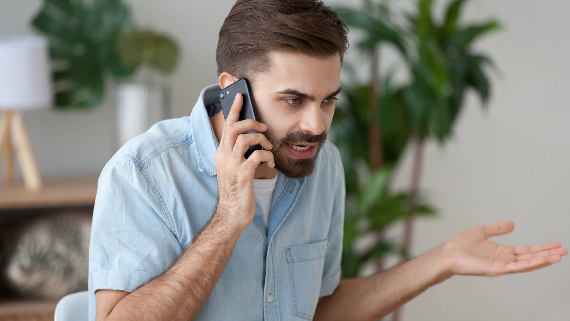 un chico enfadado llamando por telefono para poner una reclamacion a la aseguradora caser