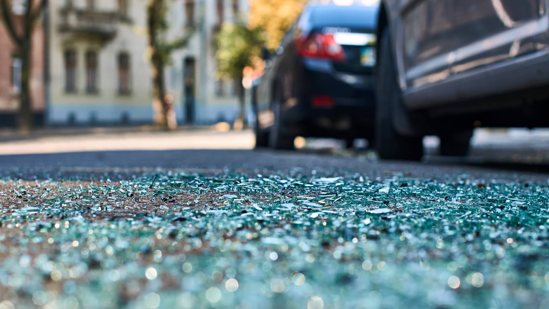 Restos de cristales de accidente y dueños y conductores rellenando parte en sus respectivos coches