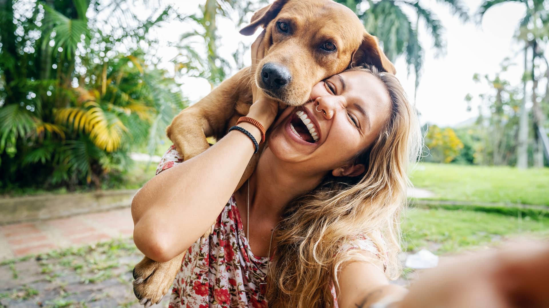 Mujer con su perro al cual tiene hecho un seguro para mascotas con catalana occidente