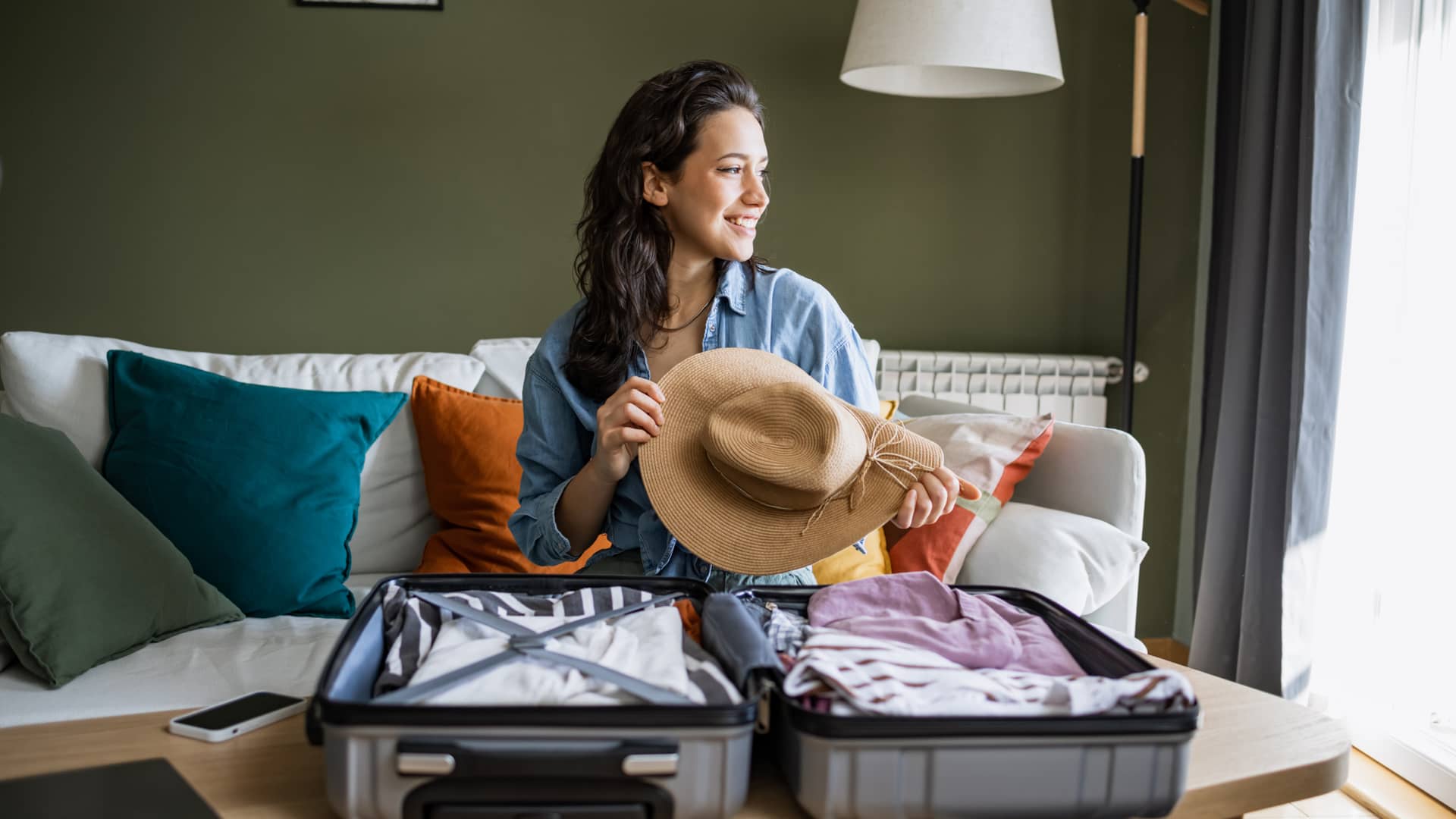 Mujer preparando su maleta para irse de vacaciones con seguro de viaje contratado con chapka