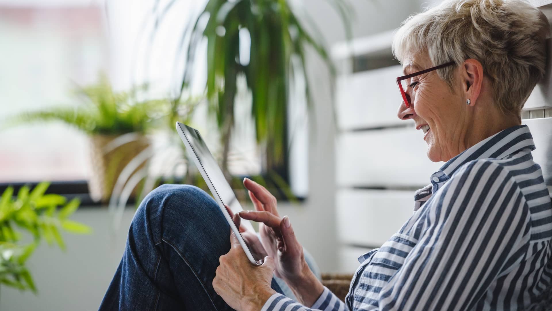una mujer adulta con su tablet revisando el area clientes de su aseguradora generali