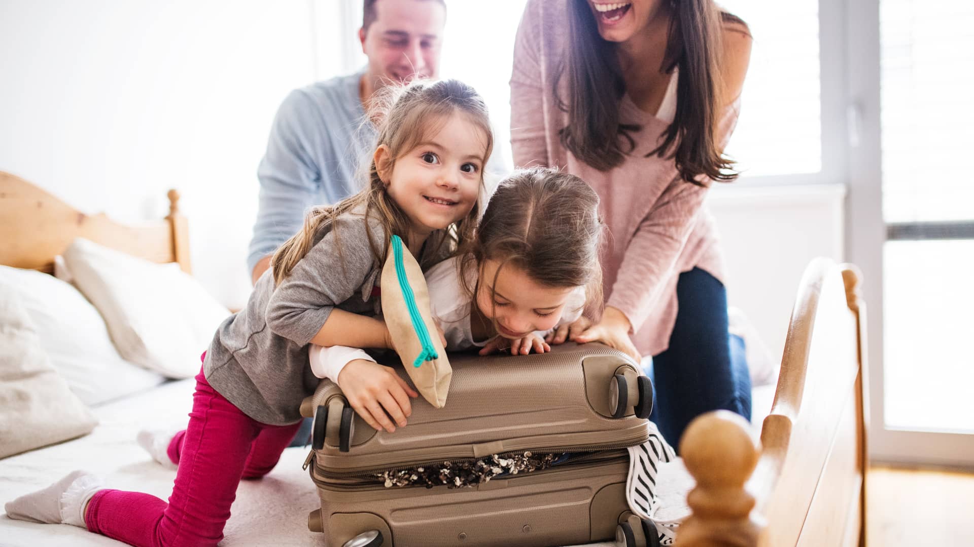 Familia preparando la maleta para irse de vacaciones con seguro de viaje imq
