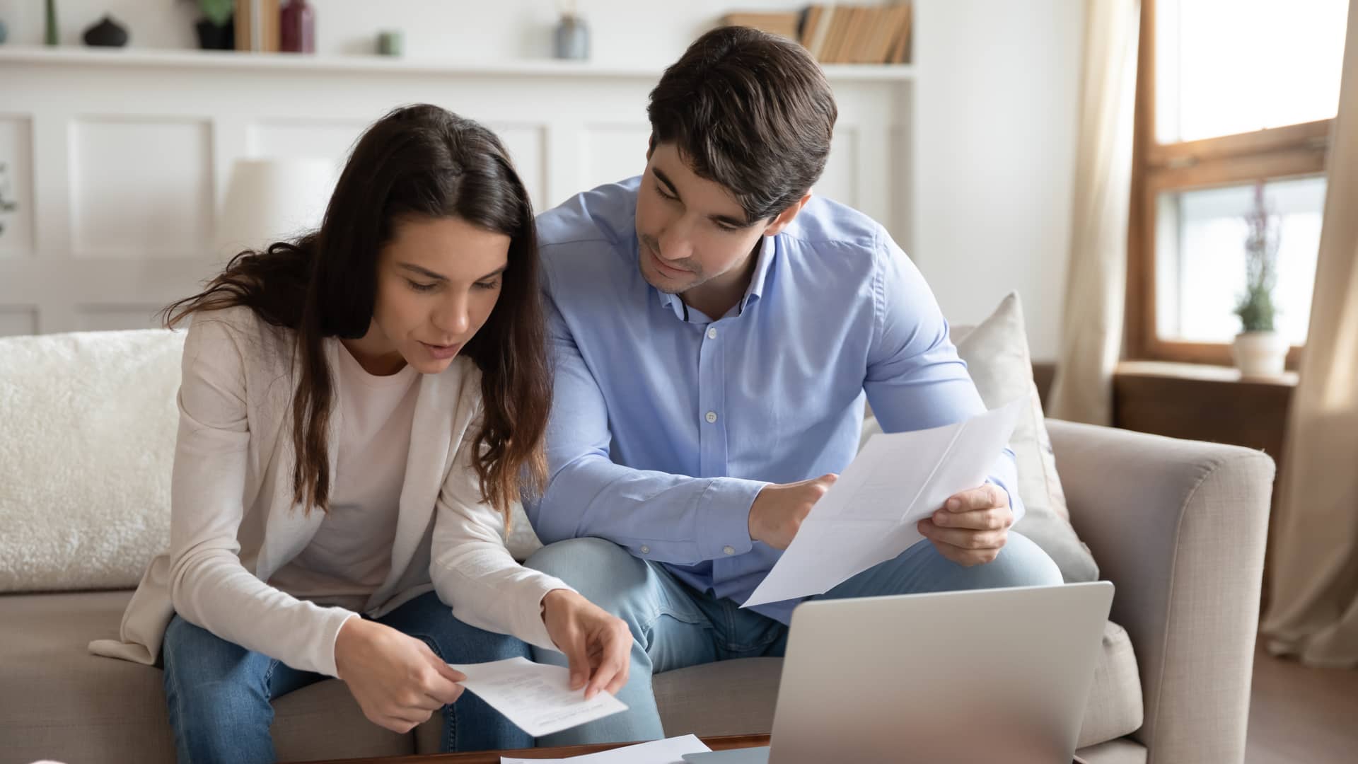 Un matrimonio joven mirando los papeles de un nuevo seguro de vida para su hipoteca con la aseguradora Mapfre