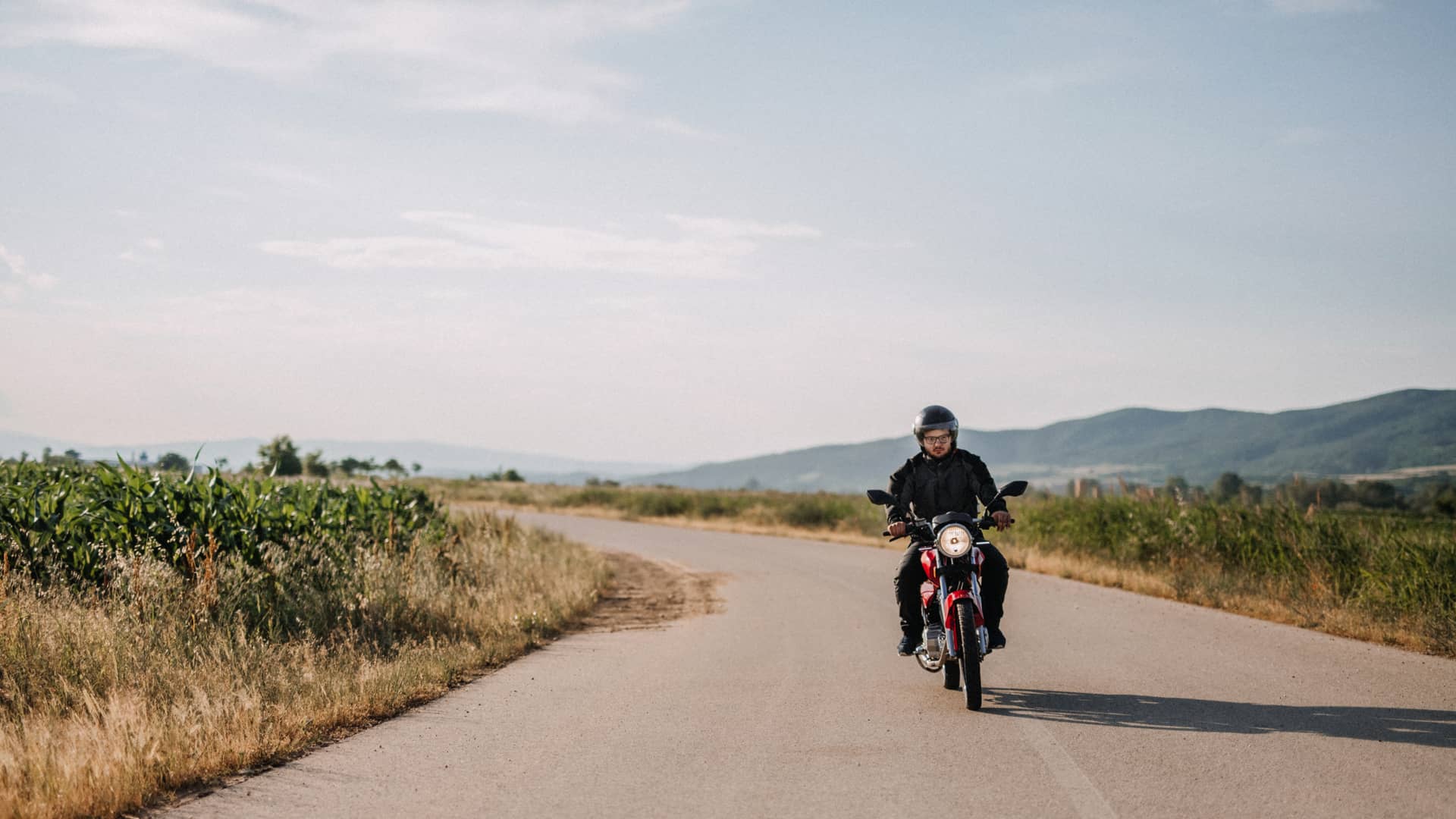 Hombre con su moto asegurada con asegurada penelope dando un paseo en moto