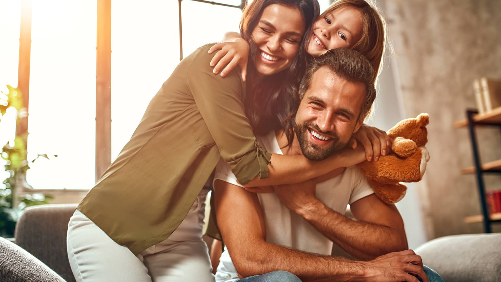 Familia sonriente en su casa asegurada con seguro de hogar con el race