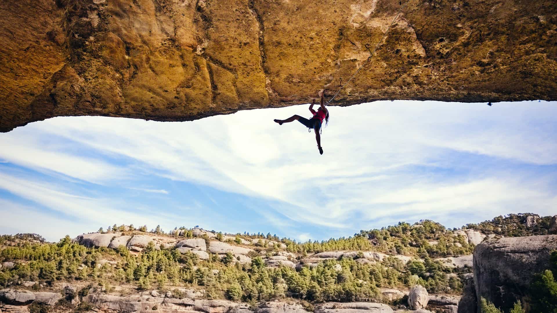 Mujer escalando una roca con seguro de vida con regal 
