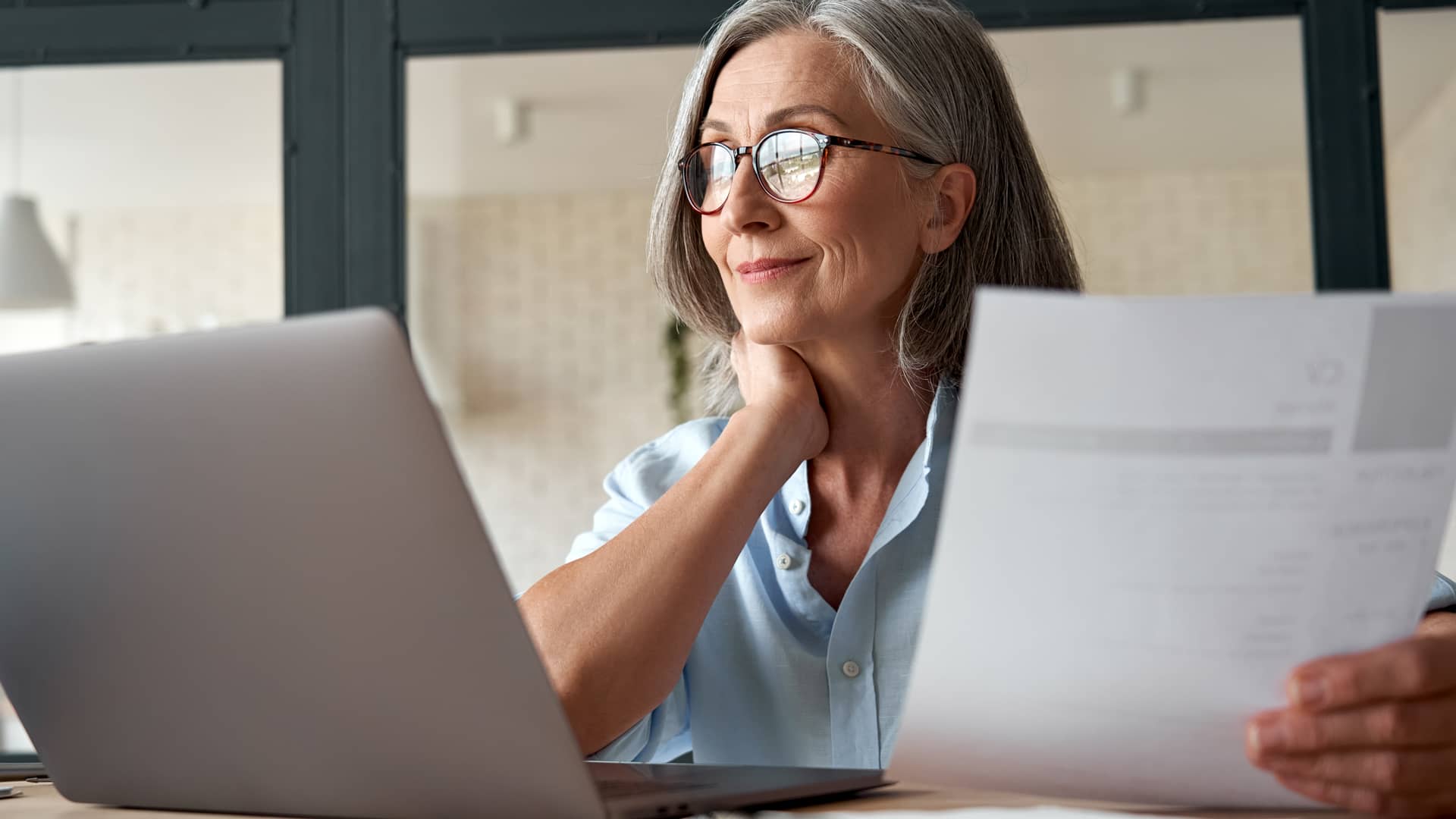 una mujer con su ordenador revisando el precio de los seguros de arendamiento