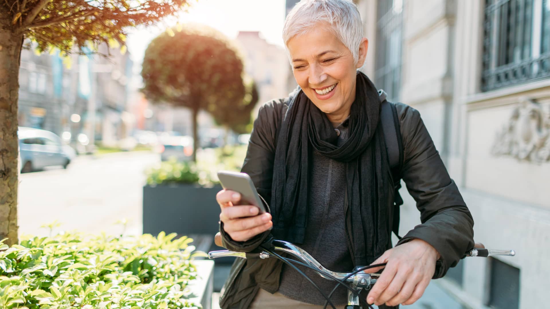 Mujer leyendo en su móvil que cubre su seguro de bicicleta