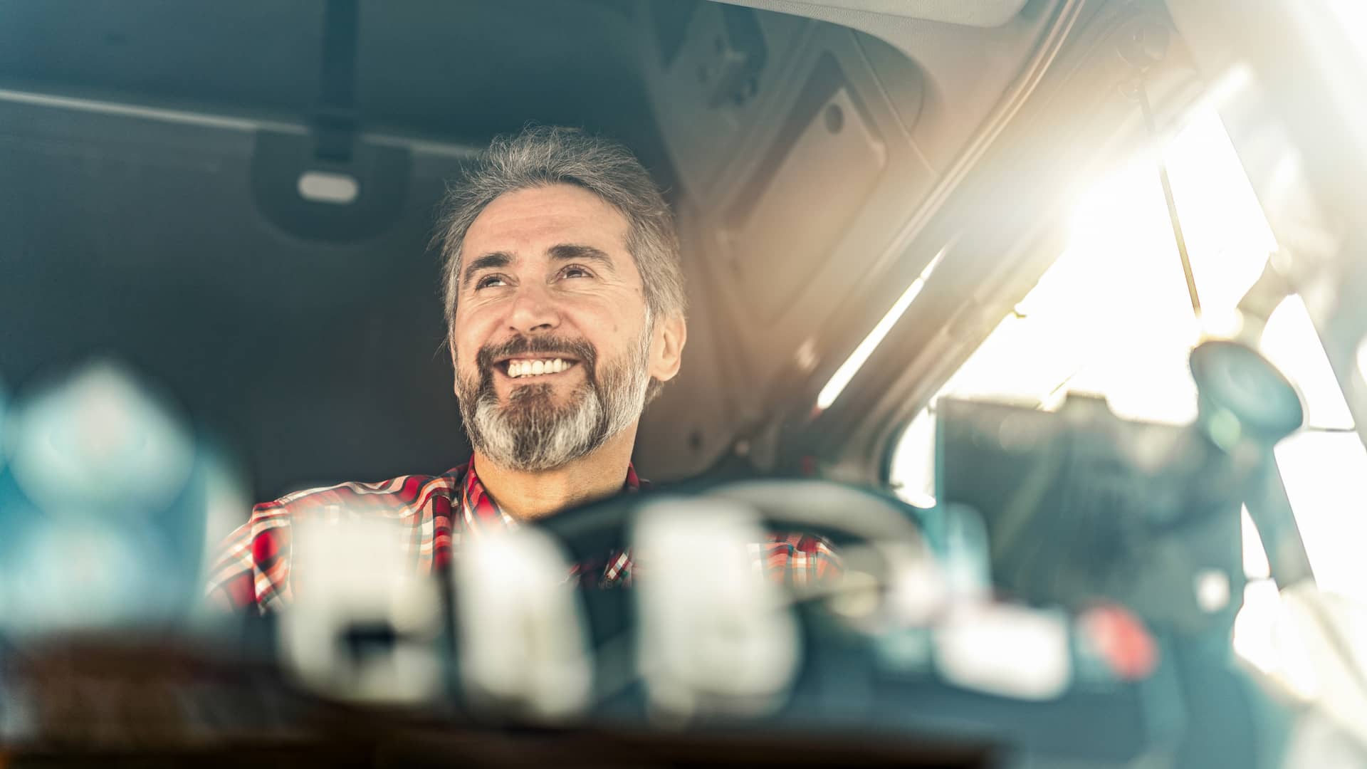 Camionero sonriente circulando con un seguro de responsabilidad civil básico