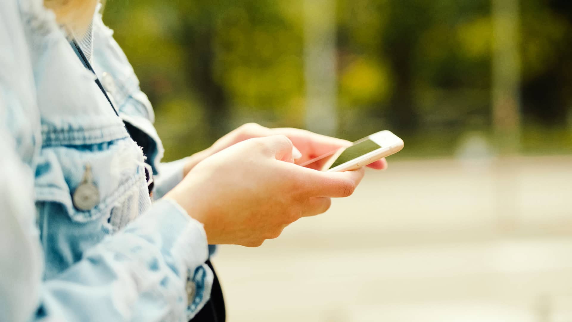 Mujer viendo en su smartphone diferentes seguros de coche para calcular el mejor precio