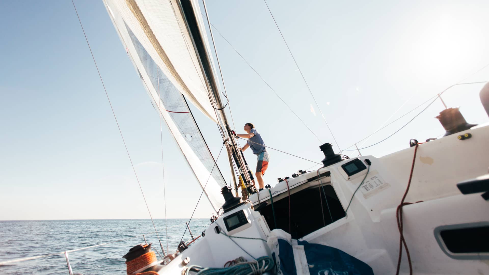 Hombre trabaja en la cubierta de su velero con la tranquilidad de contar con un seguro para embarcaciones