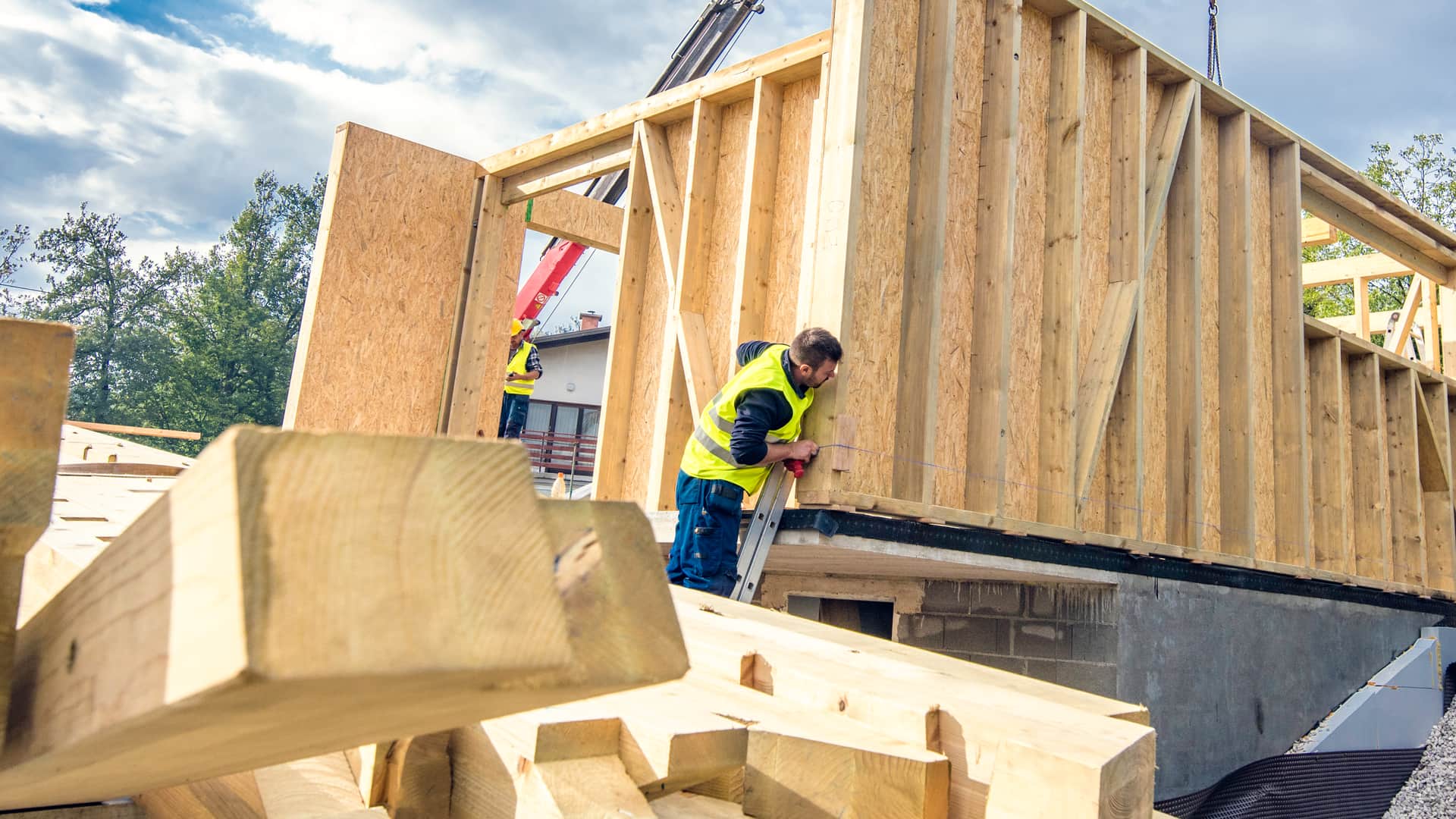 Técnicos instalando casa prefabricada con seguro de hogar sobre cimientos