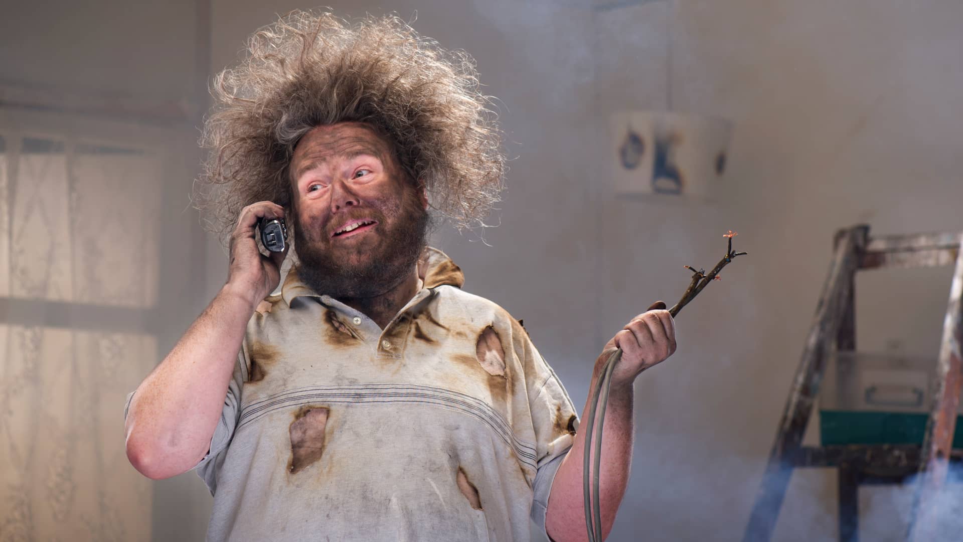 Hombre hablando por teléfono con su seguro a causa de unos daños eléctricos 