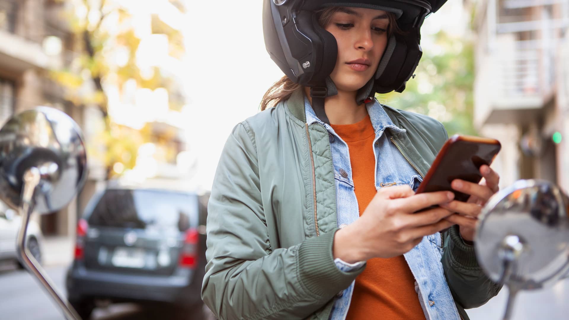 Mujer leyendo en su móvil las coberturas de su seguro de moto