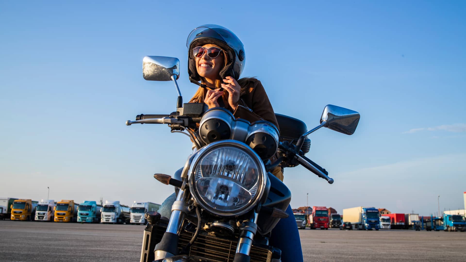 Mujer colocandose casco antes de comenzar a conducir su moto de 250 cc con seguro contratado