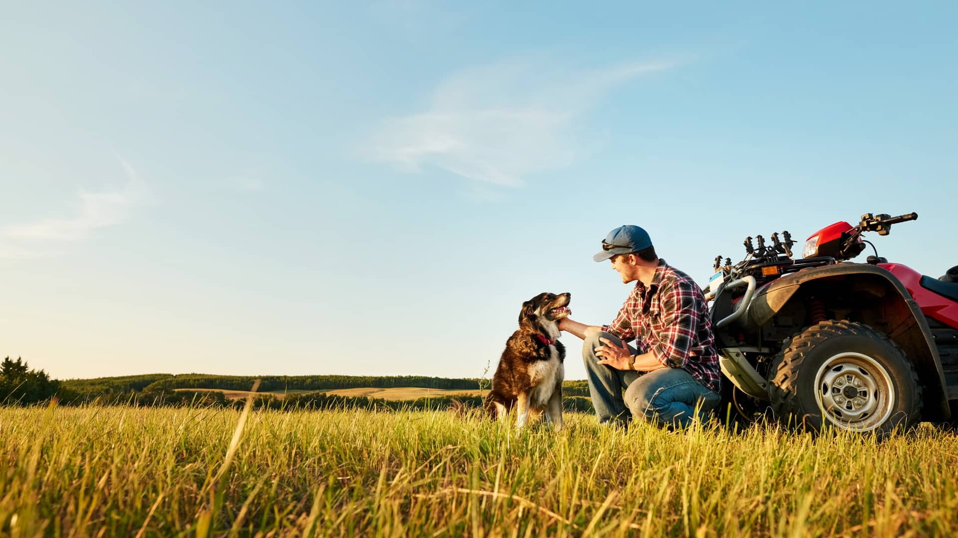Hombre disfrutando de su quad agricola junto a su perro sín ninguna preocupación gracias a su seguro