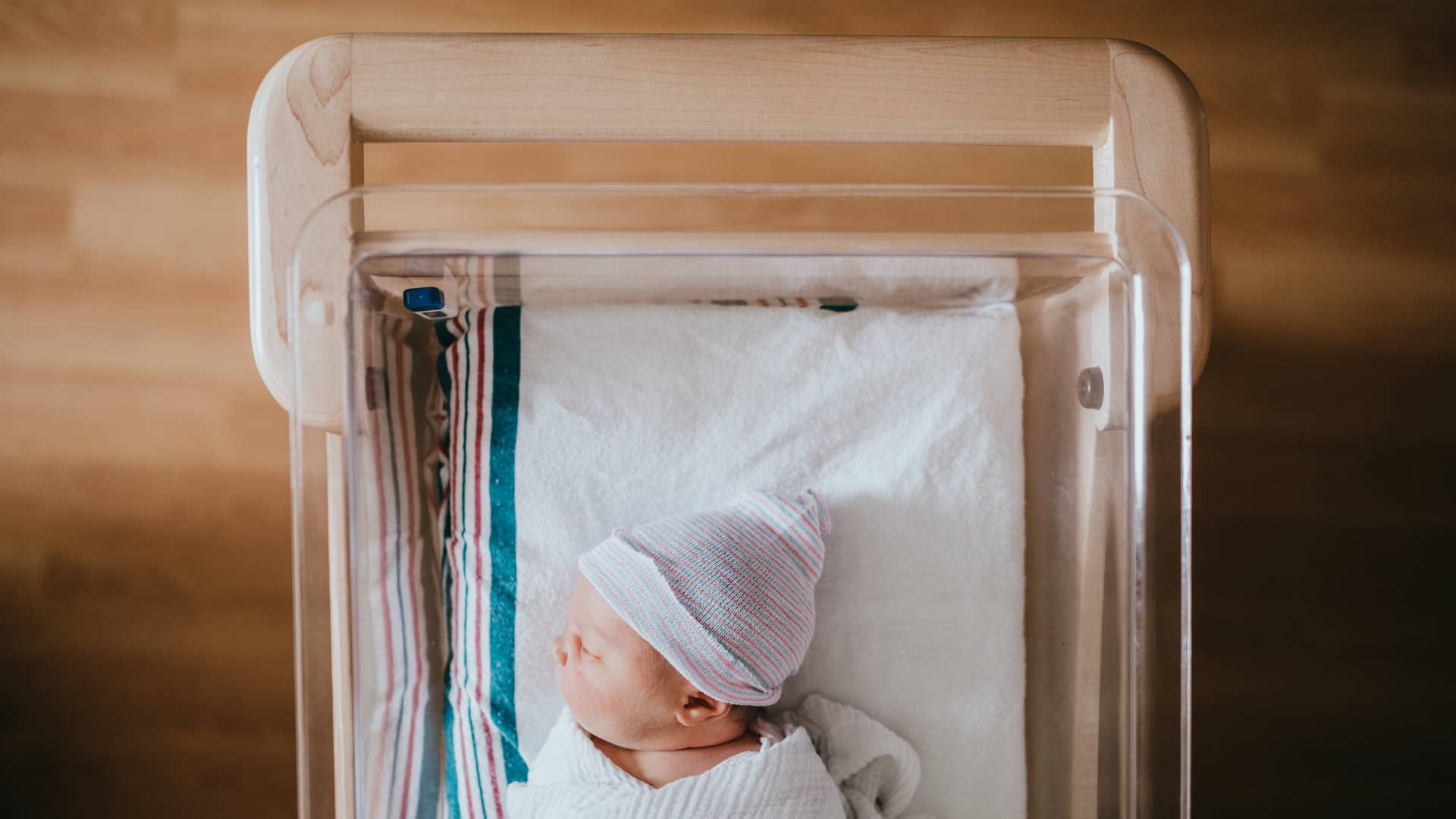 Bebé recién nacido durmiendo en cuna de Hospital al cual han guardado su cordón umbilical ya que sus padres habian contratado precisamente eso en su seguro de salud