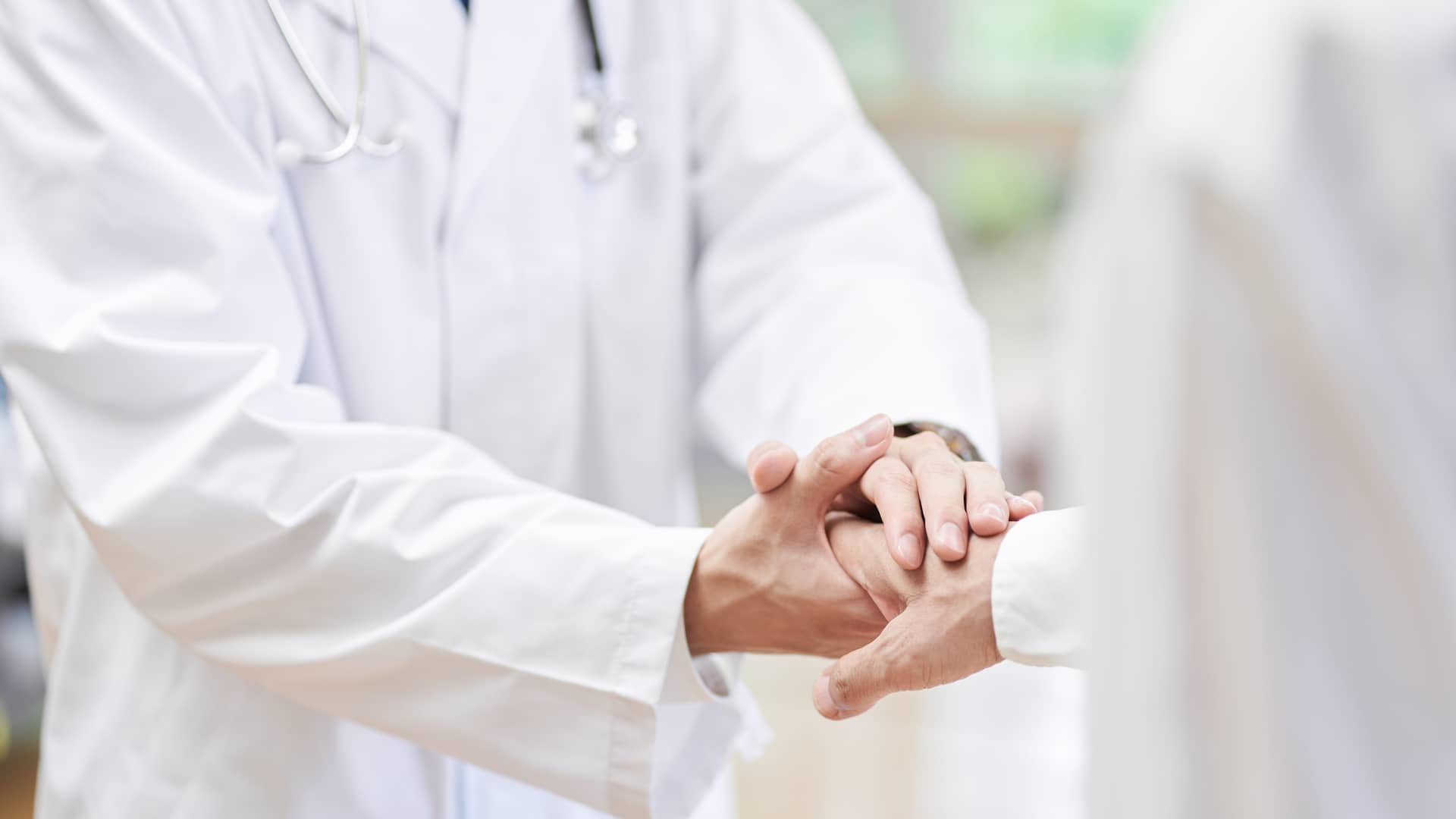 Detalle de médico dando la mano a paciente simboliza seguridad de estar en el mejor seguro médico