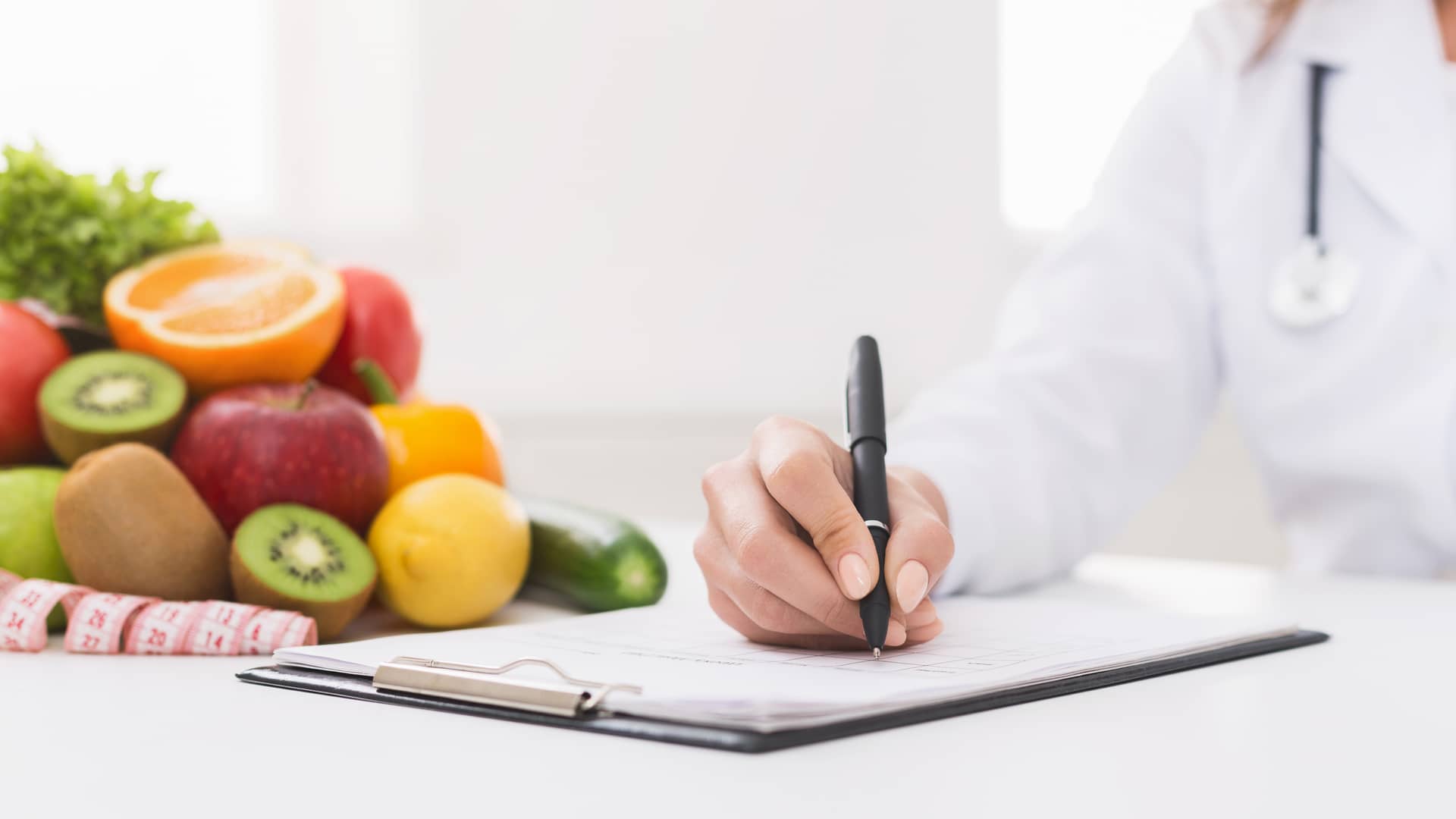 Nutricionista escribiendo informe de salud de cliente de seguro