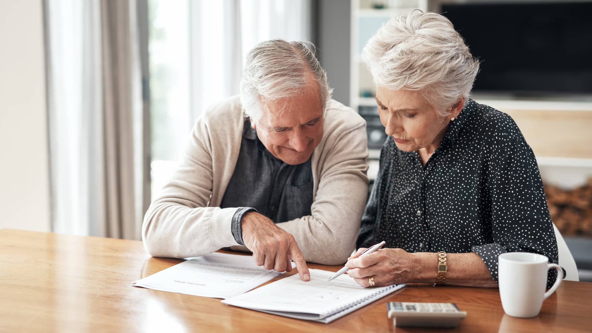 Una pareja de ancianos repasa su factura del seguro para comprobar que posibles subidas ha podido haber en su seguro de salud