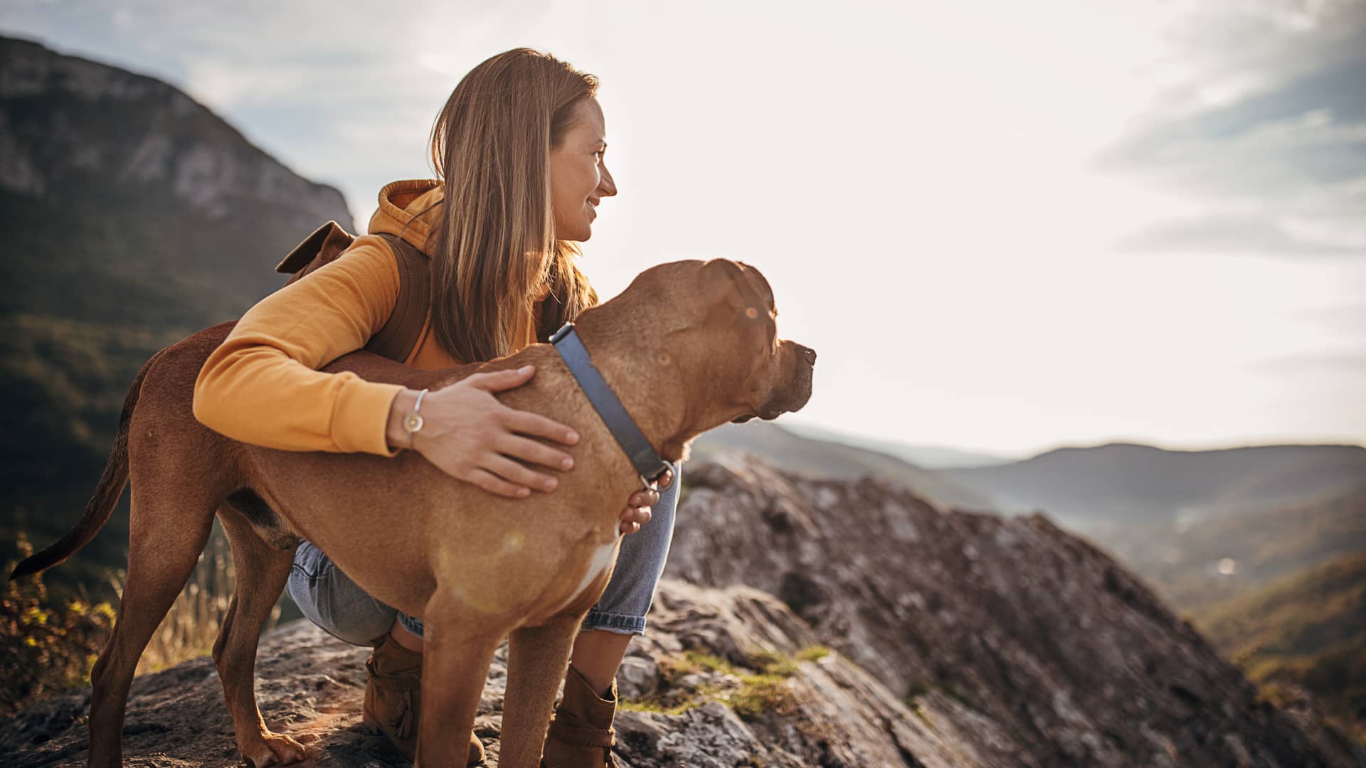 Mujer haciendo una ruta con su perro al cual le ha contratado un seguro de viaje
