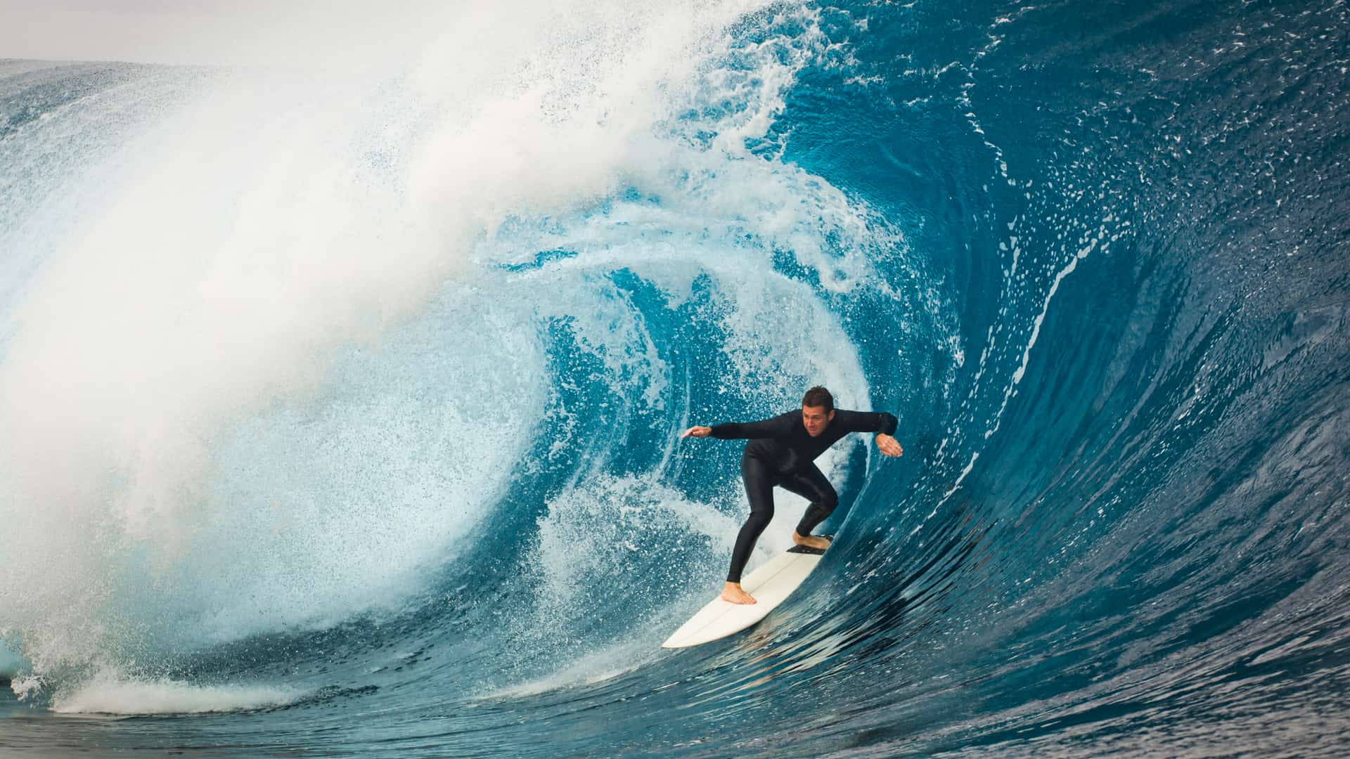 Hombre en el tubo de una ola practicando surf con la tranquilidad que le ofrece su seguro