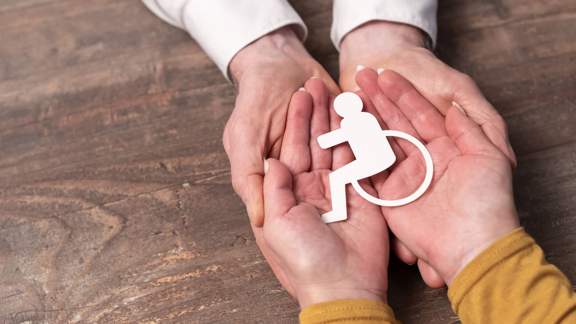 manos sosteniendo un simbolo de invalidez que simboliza el seguro de vida de invalidez permanente